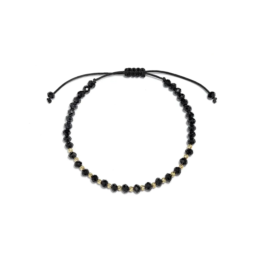 Гривна с черни мъниста и златни акценти върху текстилна връзка