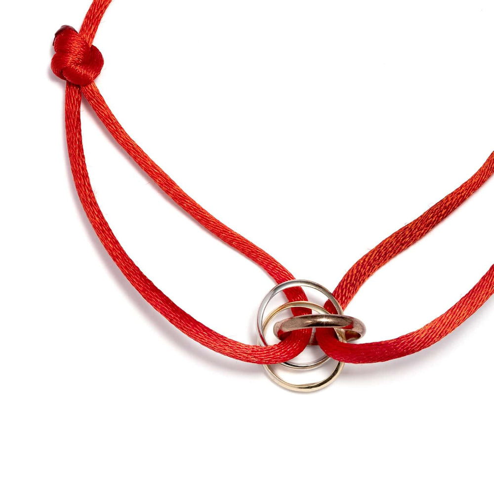 Гривна с червен конец и златни елементи в три цвята злато.