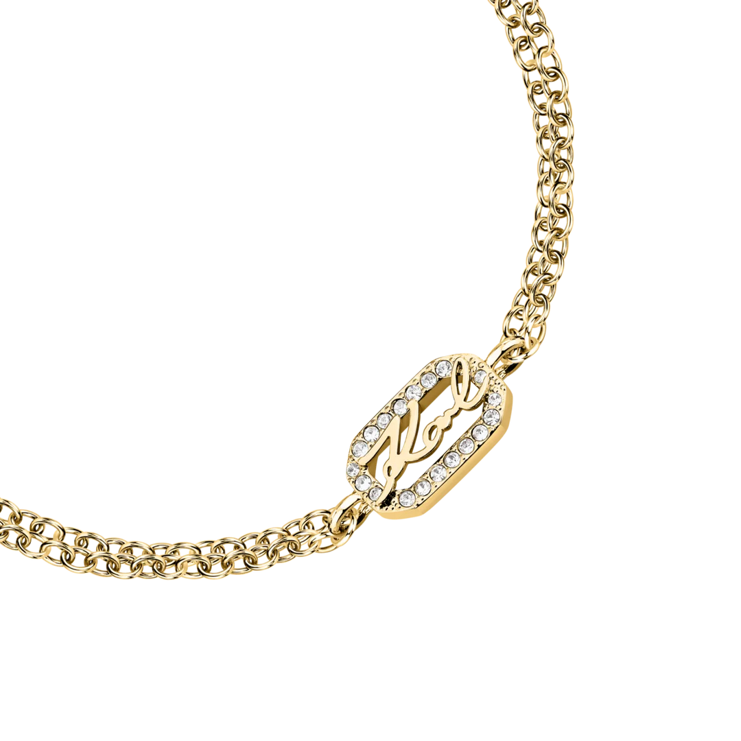 Детайлен кадър на златиста дамска гривна Karl Lagerfeld с логото Karl и бели кристали – KLAYC32